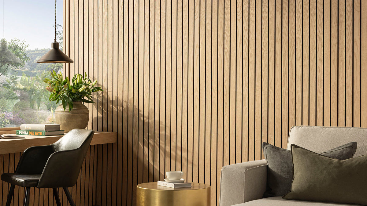 SlatWall Grand Oiled Oak panels in a living area with neutral and green seating, a gold table and a pendant ceiling light. 