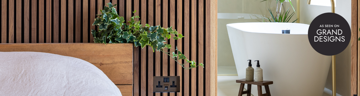 SlatWall Deep Walnut on wall behind bed with wooden frame and white bedding. Bath in ensuite in background